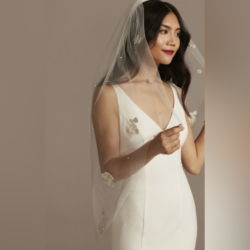 3D scattered floral and pearl fingertip veil. The color is ivory/cashmere.